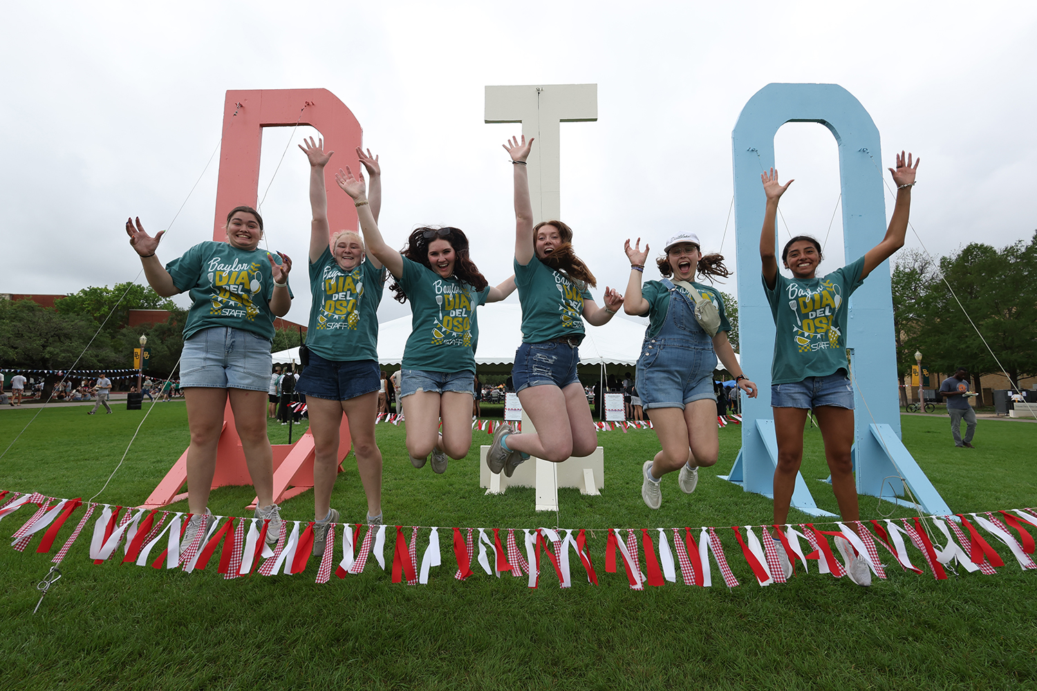 Baylor Students jumping in front of a DIA sign